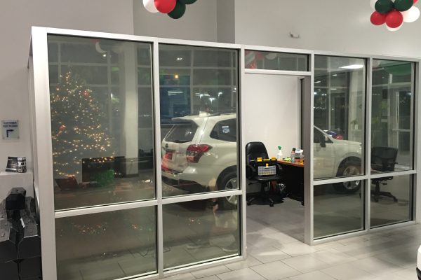 A car is parked in the showroom window.
