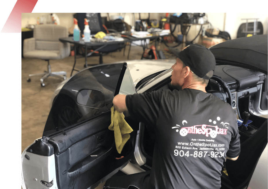 A man cleaning the back of a car.